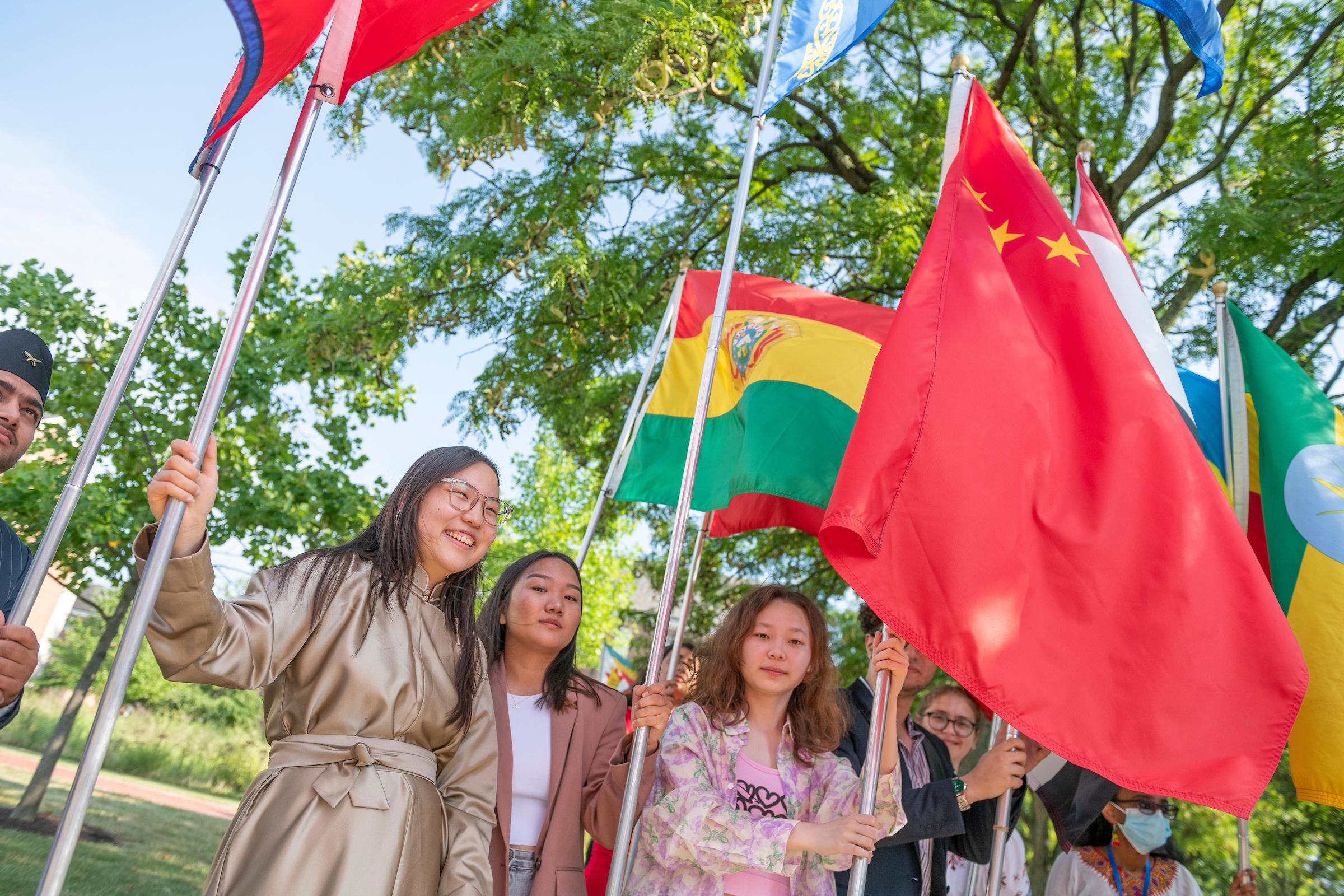 留学生站在自己国家的国旗前&M召开.